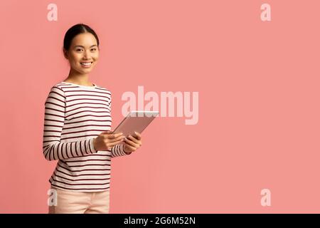 Technologies modernes pour les loisirs. Portrait de la jeune femme asiatique à l'aide d'une tablette numérique Banque D'Images