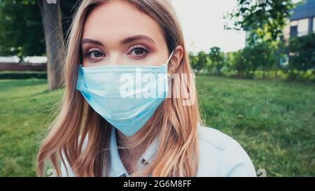 jeune femme en bleu masque médical regardant l'appareil photo Banque D'Images