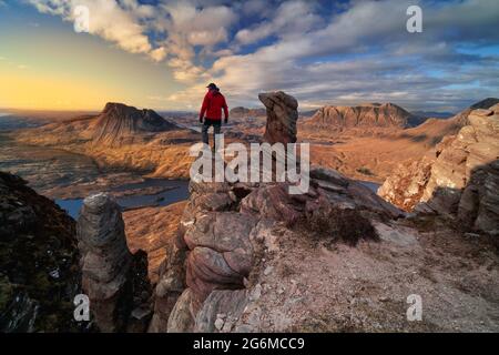 Randonneur méconnaissable qui prend la vue sur le paysage d'Assynt au coucher du soleil. Situé dans les hauts plateaux du nord-ouest de l'écosse. Banque D'Images