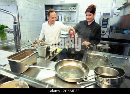 Stuttgart, Allemagne. 07e juillet 2021. Les cuisiniers travaillent sur une sauce dans la cuisine d'un restaurant. Il y a une pénurie de travailleurs qualifiés dans l'industrie de l'hôtellerie et de la restauration après la crise de Corona. Credit: Bernd Weißbrod/dpa/Alay Live News Banque D'Images