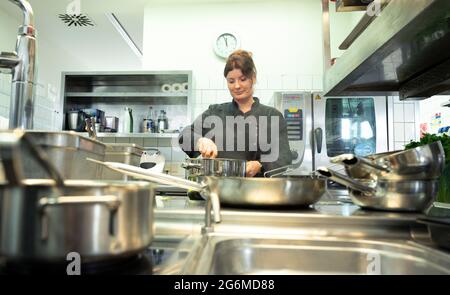 Stuttgart, Allemagne. 07e juillet 2021. Un cuisinier travaille sur une sauce dans la cuisine d'un restaurant. Il y a une pénurie de travailleurs qualifiés dans l'industrie de l'hôtellerie et de la restauration après la crise de Corona. Credit: Bernd Weißbrod/dpa/Alay Live News Banque D'Images