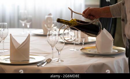 Stuttgart, Allemagne. 07e juillet 2021. Un employé du restaurant verse du vin à une table fixe (scène posée). Il y a une pénurie de travailleurs qualifiés dans l'industrie de l'hôtellerie et de la restauration après la crise de Corona. Credit: Bernd Weißbrod/dpa/Alay Live News Banque D'Images