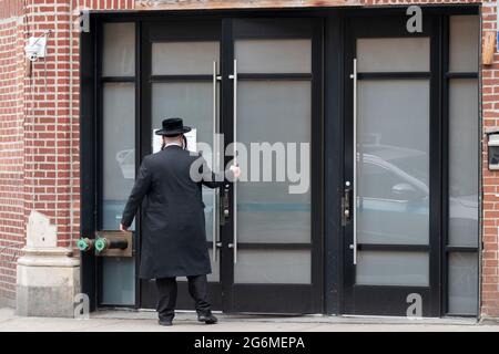 Un juif orthodoxe non identifié entre dans une synagogue pour les services du matin. Sur Lee Avenue à Williamsburg, Brooklyn, New York. Banque D'Images