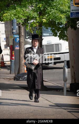 Un juif orthodoxe rentrent des services du matin sur Lee Ave et porte son sac de tallis et de tefillin. À Williamsburg, Brooklyn Banque D'Images