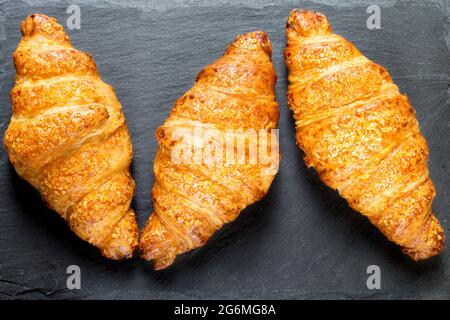 trois délicieux croissants sur fond de pierre noire. Cuisine française. Gros plan. Touche Bas Banque D'Images