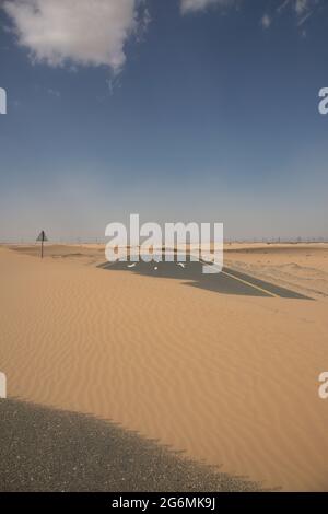 Sable couvrant la route à Dubaï, Émirats Arabes Unis. Banque D'Images