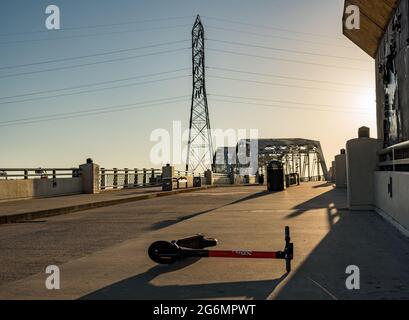 Nashville, Tennessee - 28 juin 2021 : le scooter électrique spin est abandonné sur le pont piétonnier près de Broadway et du centre de divertissement Banque D'Images