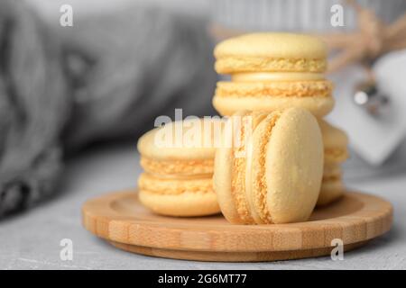 Un groupe de trois macarons jaune pastel sur fond gris clair, espace de copie et gros plan Banque D'Images