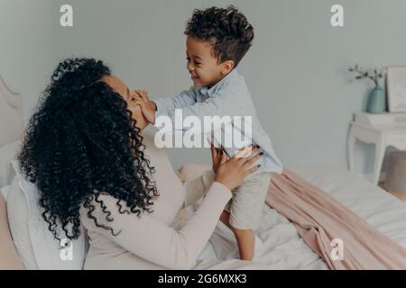 Femme afro-américaine enceinte jouant avec son fils à la maison Banque D'Images