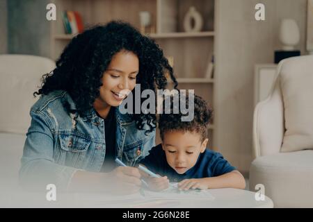 Joli dessin de maman et de petit garçon afro-américain avec des stylos à pointe feutre de couleur Banque D'Images