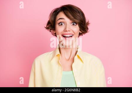 Photo de doux drôle impressionné jeune femme habillé jaune chemise sourire grands yeux isolé couleur rose fond Banque D'Images