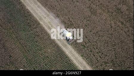 Vue en plan à grand angle de la moissonneuse-batteuse par drone lors de la récolte des champs agricoles de céréales. Banque D'Images