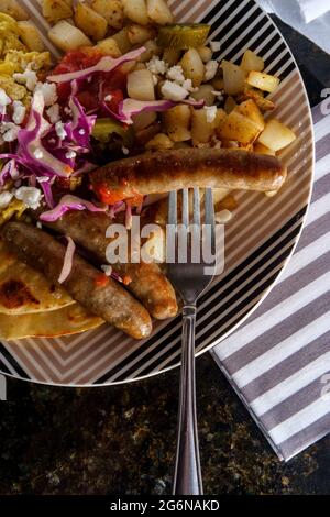 Petit-déjeuner mexicain huevos rancheros oeufs brouillés tostada avec saucisse pommes de terre sauce tomate et queso fresco servi sur tortilla au maïs frit Banque D'Images