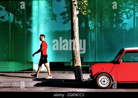 Homme marchant dans la rue sans masque facial après un mini-parking, Barcelone, Espagne. Banque D'Images