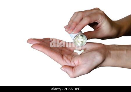 Des pilules médicinales sont déversées de la bouteille de pilule sur le bras. Probiotiques, vitamines, comprimés. Concept de médecine isolé sur fond blanc. Guérir votre Banque D'Images