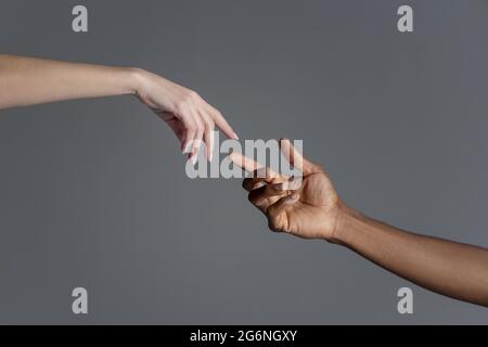 Les mains mâles et femelles se retouchant l'une à l'autre en copiant la création du signe Adam. Banque D'Images