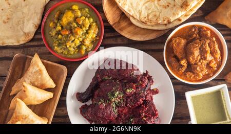 Table avec un dîner composé de divers plats de curry sur une table rustique en bois Banque D'Images