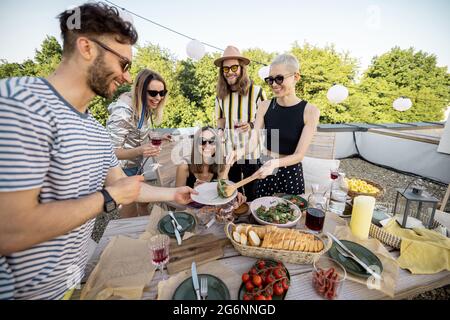 Amis partageant de la nourriture au dîner à l'extérieur Banque D'Images