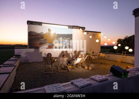 Les gens regardent des films sur la terrasse sur le toit au coucher du soleil Banque D'Images