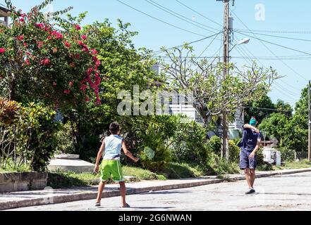 Deux frères latins pratiquant le badminton dans la rue en période de pandémie Banque D'Images