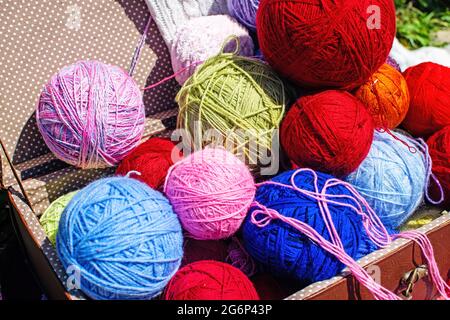 Balles de fils multicolores colorés dans une vieille valise. Tricoter le fil de laine. Une idée pour un espace photographique. Mise au point sélective. Banque D'Images