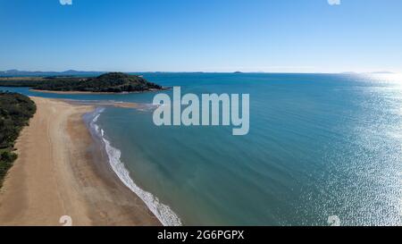 Paysage aérien d'une longue plage de sable avec des vagues de l'océan qui se lancerent sur le rivage lors d'une matinée claire et nette. Louisa Creek, Mackay, Queensland, Australie. Banque D'Images