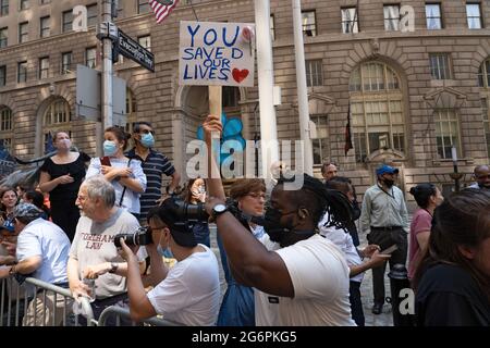 NEW YORK, NY - 07 JUILLET : des spectateurs avec des panneaux remerciant les travailleurs essentiels regardent la « Hometown Heroes » Ticker Tape Parade le 07 juillet 2021 à New York. Les travailleurs de la santé, les premiers intervenants et les travailleurs essentiels ont été honorés dans le Canyon of Heroes de Manhattan pour leur service durant la pandémie COVID-19. Banque D'Images