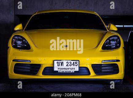 Bangkok, Thaïlande - 30 juin 2021 : vue de face d'une voiture de sport Porsche jaune garée dans le parking. Mise au point sélective. Banque D'Images