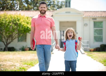 Père et fils vont à l'école, à l'éducation et à l'apprentissage. Garçon d'école allant à l'école avec père. Banque D'Images