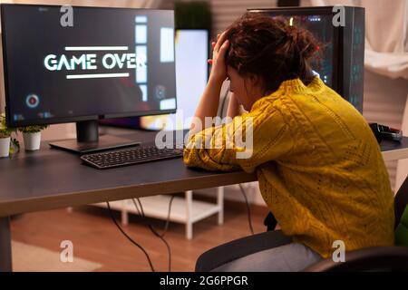 Un joueur pro en colère en jouant à des jeux de tir beacuse elle perd. Plus de joueur de jeu vidéo de maquette, en jouant dans la cyber-salle élégante, le jeu de tir virtuel dans le cyberespace, le tournoi de jeu de pc. Banque D'Images