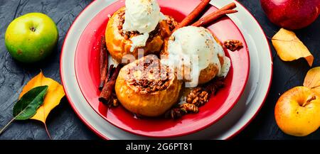 Dessert d'automne, pommes cuites au four avec granola et noix. Pommes savoureuses cuites au four avec crème glacée Banque D'Images