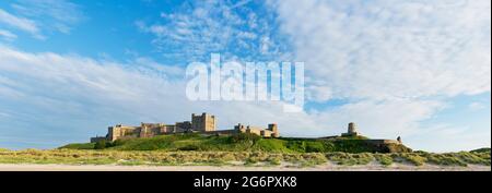 Vue panoramique montrant le château de Bamburgh le long de la côte pendant l'été, Bamburgh, Northumberland, Royaume-Uni Banque D'Images