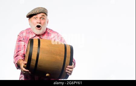 Winery concept. Vin maison. Barbu homme porter senior pour le vin tonneau en bois fond blanc. La production de vin tradition familiale. Produits de fermentation Banque D'Images
