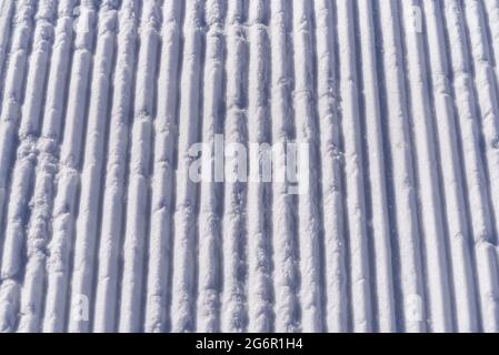 Texture des lignes de neige à partir d'une machine à neige sur une piste de ski. Banque D'Images
