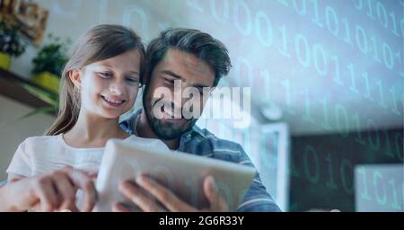 Traitement binaire des données de codage contre le père et la fille caucasiens utilisant une tablette numérique à la maison Banque D'Images