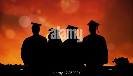 Composition de silhouettes d'étudiants diplômés en casquettes et robes contre le ciel du coucher du soleil Banque D'Images