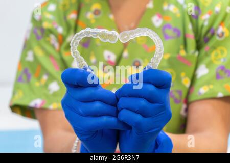 Femme médecin médecin faisant la forme du coeur avec des aligneurs de dents Banque D'Images