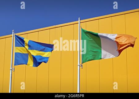 Drapeaux irlandais et suédois sur fond bleu et jaune. Banque D'Images