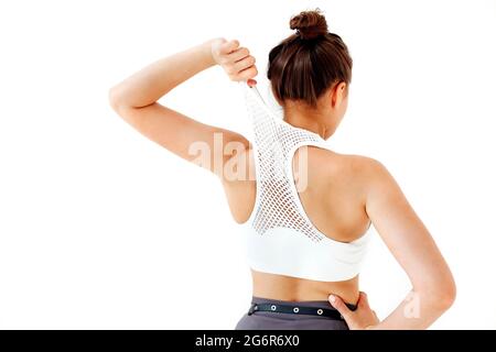 Vue arrière d'une femme anonyme avec main à la taille tirant et étirant élégant haut court sur fond blanc Banque D'Images