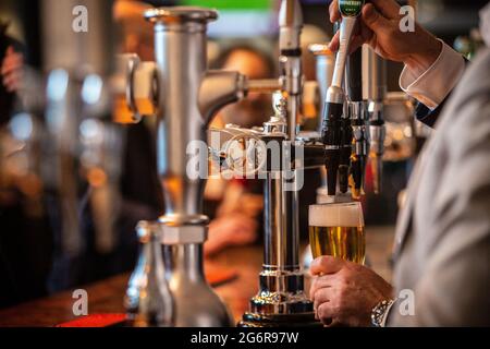 Une pinte de bière / bière servie depuis l'arrière du bar dans le pub Banque D'Images