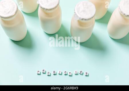 Petits flacons avec probiotiques et prébiotiques boisson laitière sur fond bleu. Production avec des additifs biologiquement actifs. Fermentation et alimentation Banque D'Images