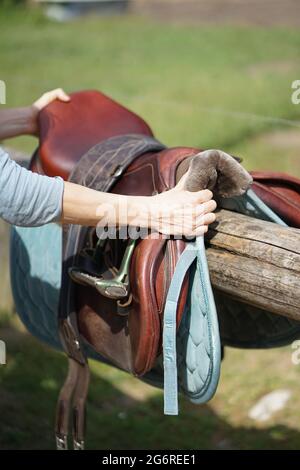 Mains prenant cheval selle pour l'équitation Banque D'Images