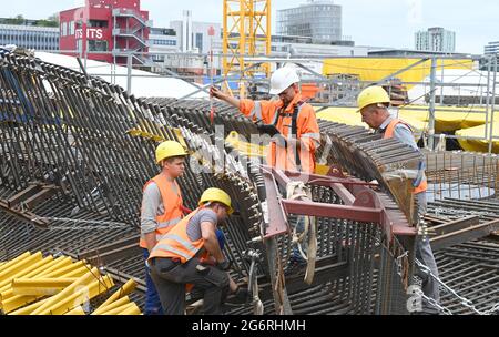 08 juillet 2021, Baden-Wuerttemberg, Stuttgart: Les travailleurs attachent des pièces d'un renfort sur le grand chantier de construction de la nouvelle gare, qui sera ensuite versée avec du béton. Le projet ferroviaire Stuttgart 21, qui vaut des milliards, implique de déplacer la station de métro. Photo: Bernd Weißbrod/dpa Banque D'Images