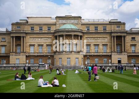 Les visiteurs peuvent pique-niquer sur la pelouse pendant un aperçu du jardin de Buckingham Palace, résidence officielle de la reine Elizabeth II à Londres, qui s'ouvre au public vendredi. Les visiteurs pourront pique-niquer dans le jardin et explorer l'espace ouvert pour la première fois. Date de la photo: Jeudi 8 juillet 2021. Banque D'Images