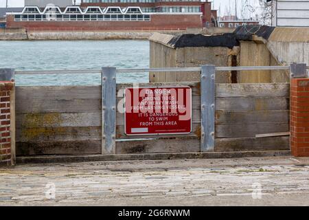 Un panneau d'avertissement sur les portes d'inondation qui indique danger marées fortes et lavage intensif des navires qui passent il est dangereux de nager dans cette zone Banque D'Images