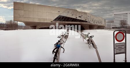 Main courante d'entrée devant le Phaeno, un paysage expérimental moderne fait par Zaha Hadid , neige profonde avec des vélos enchaînés, panorama, cousu en W Banque D'Images