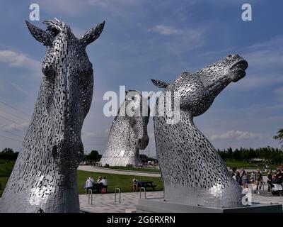 Une vue inhabituelle de 3 kelpies tandis que les Kelpie Maquettes encadrent l'une des Kelpies pleine grandeur, des sculptures à tête de cheval par l'artiste Andy Scott, Falkirk, Écosse Banque D'Images