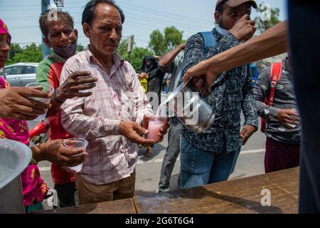 Ghaziabad, Inde. 08 juillet 2021. Sharbat, une boisson sucrée est distribuée par les commerçants locaux aux personnes qui volent un jour ensoleillé sur GT Road, Old Ghaziabad. La température maximale enregistrée à Delhi le 30 juin 2021 était de 43.73 degrés Celsius. C'est la deuxième température la plus élevée de ce jour depuis 1951. Le retard des pluies de mousson dans plusieurs parties du nord de l'Inde a également entraîné une température élevée. Crédit : SOPA Images Limited/Alamy Live News Banque D'Images