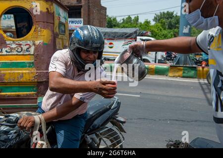 Ghaziabad, Inde. 08 juillet 2021. Sharbat, une boisson sucrée est distribuée par les commerçants locaux aux personnes qui volent un jour ensoleillé sur GT Road, Old Ghaziabad. La température maximale enregistrée à Delhi le 30 juin 2021 était de 43.73 degrés Celsius. C'est la deuxième température la plus élevée de ce jour depuis 1951. Le retard des pluies de mousson dans plusieurs parties du nord de l'Inde a également entraîné une température élevée. Crédit : SOPA Images Limited/Alamy Live News Banque D'Images