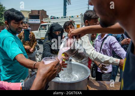 Ghaziabad, Inde. 08 juillet 2021. Sharbat, une boisson sucrée est distribuée par les commerçants locaux aux personnes qui volent un jour ensoleillé sur GT Road, Old Ghaziabad. La température maximale enregistrée à Delhi le 30 juin 2021 était de 43.73 degrés Celsius. C'est la deuxième température la plus élevée de ce jour depuis 1951. Le retard des pluies de mousson dans plusieurs parties du nord de l'Inde a également entraîné une température élevée. (Photo de Pradeep Gaur/SOPA Images/Sipa USA) crédit: SIPA USA/Alay Live News Banque D'Images